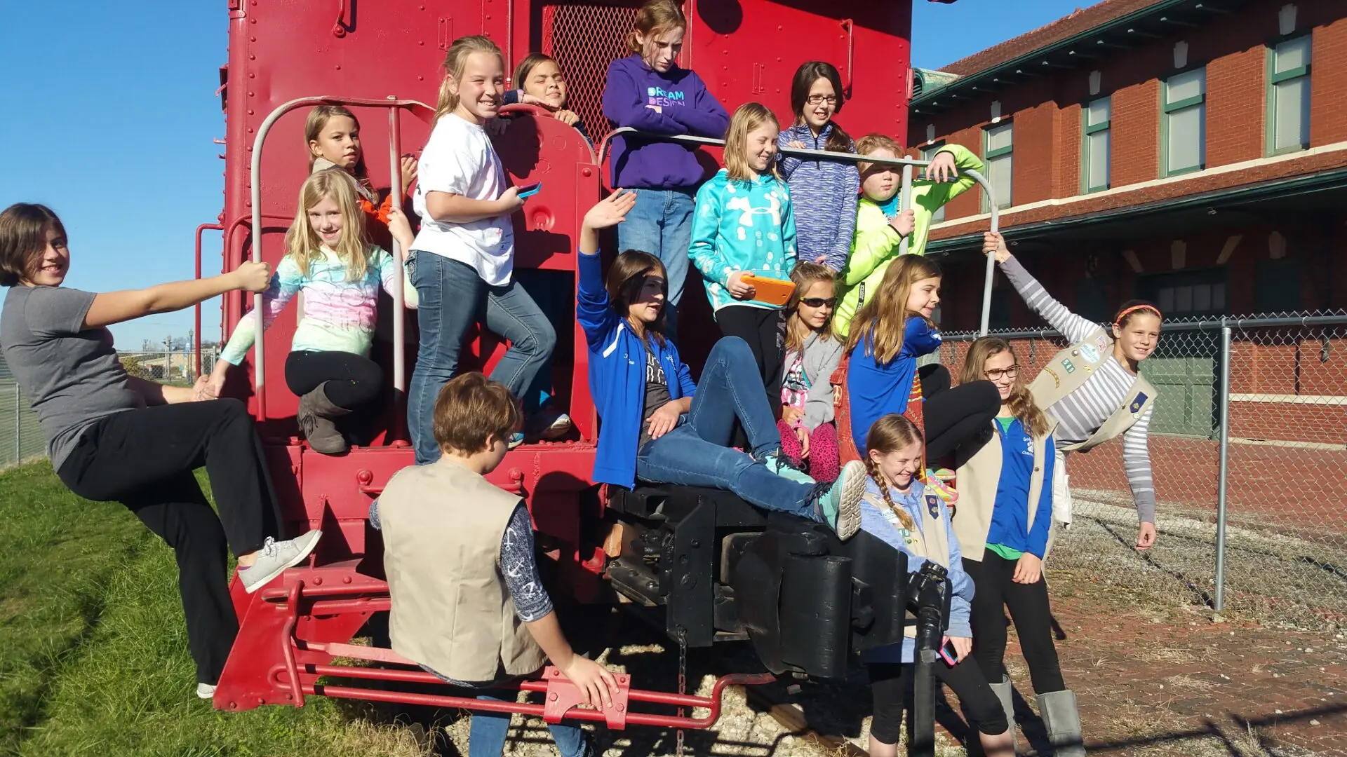 Girl scouts caboose train behind depot